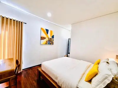 a white bedroom with a bed and a desk at Bali 3BR Family Nicho House in Seminyak