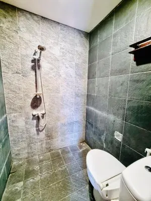 a bathroom with a toilet and a shower at Bali 3BR Family Nicho House in Seminyak