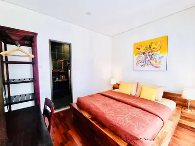 a bedroom with a bed with a red bedspread at Bali 3BR Family Nicho House in Seminyak