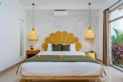 a bedroom with a large bed and two pendant lights at Villa Aarna - Tropical Chic Private Oasis in Seminyak in Seminyak