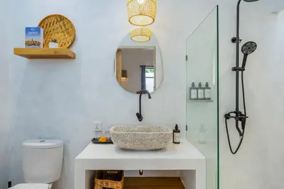 a bathroom with a sink and a glass shower at Villa Aarna - Tropical Chic Private Oasis in Seminyak in Seminyak