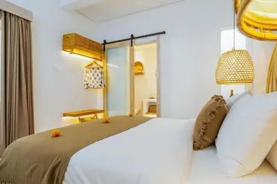 a bedroom with a white bed and a mirror at Villa Aarna - Tropical Chic Private Oasis in Seminyak in Seminyak