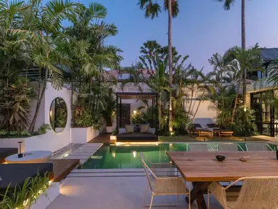 an outdoor dining area with a table and a swimming pool at Villa Naura Umalas in Dalung
