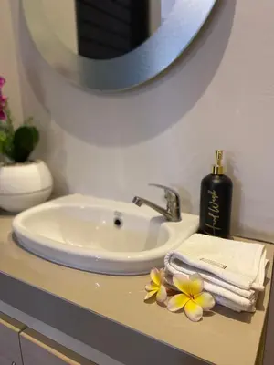 a bathroom sink with towels and flowers on a counter at Queen’s Villa in Seminyak