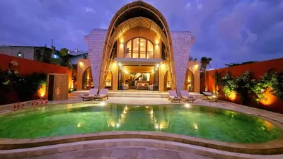 a large swimming pool in front of a building at Bamboo Estate Legian in Legian