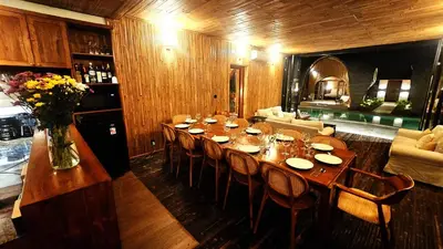 a dining room with a long table and chairs at Bamboo Estate Legian in Legian
