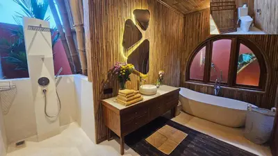 a bathroom with a bath tub and a sink at Bamboo Estate Legian in Legian
