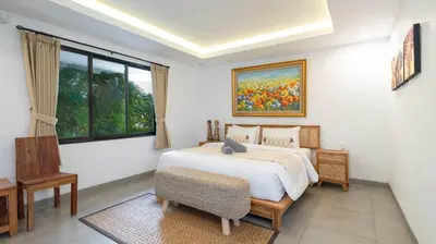 a bedroom with a bed and a painting on the wall at Villa Ambalika by Villa Finder in Seminyak