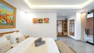 a bedroom with a bed and a painting on the wall at Villa Ambalika by Villa Finder in Seminyak
