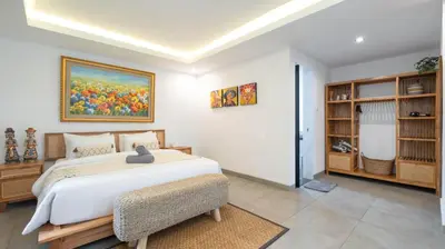 a bedroom with a bed and a painting on the wall at Villa Ambalika by Villa Finder in Seminyak