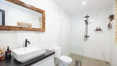 a white bathroom with a sink and a toilet at Villa Ambalika by Villa Finder in Seminyak