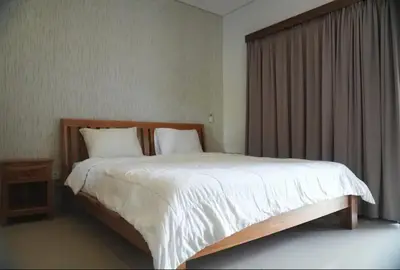 a bedroom with a large white bed and a window at Doris Seminyak Studio in Seminyak