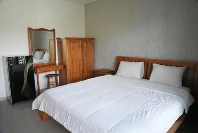 a bedroom with a large white bed and a mirror at Doris Seminyak Studio in Seminyak