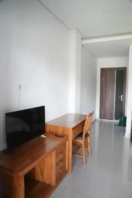 a desk with a television and a chair in a room at Doris Seminyak Studio in Seminyak