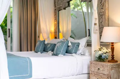 a bedroom with a bed with blue and white pillows at Villa Sunsara 4 - Enchanting 4BR Villa in a Great Location in Canggu