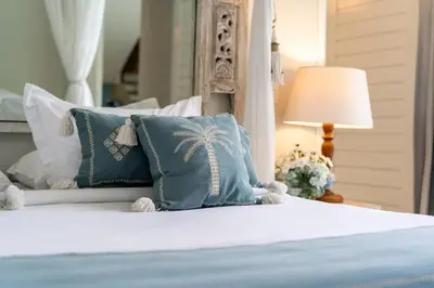 a bed with blue and white pillows and a lamp at Villa Sunsara 4 - Enchanting 4BR Villa in a Great Location in Canggu