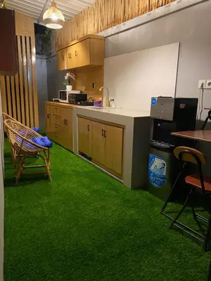 a kitchen with green flooring and a table and chairs at Queens Villa in Seminyak