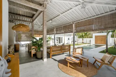 a living room with a bench and a pool at Villa Surga Julie by Alfred in Bali in Seminyak