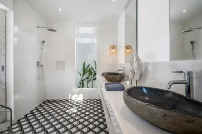 a bathroom with a large tub and two sinks at Villa Surga Julie by Alfred in Bali in Seminyak