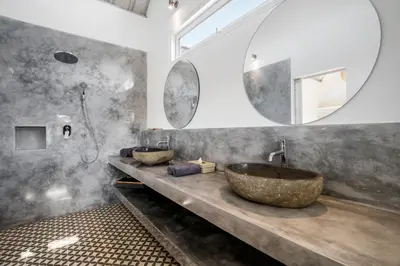 a bathroom with a large stone sink and a shower at Villa Surga Julie by Alfred in Bali in Seminyak