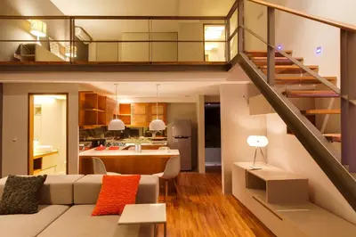 a living room and kitchen with a staircase in a house at Petitenget 501 in Seminyak