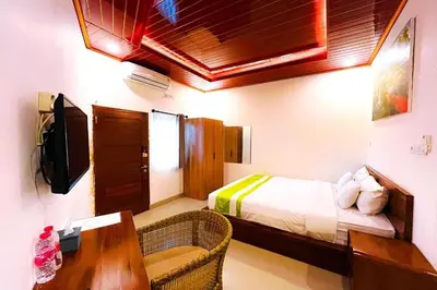 a bedroom with a bed and a desk and a table at Mora Residence Jimbaran in Jimbaran