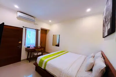 a bedroom with a bed and a desk and a window at Mora Residence Jimbaran in Jimbaran