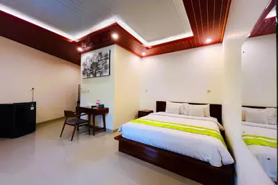 a bedroom with a large bed and a desk at Mora Residence Jimbaran in Jimbaran