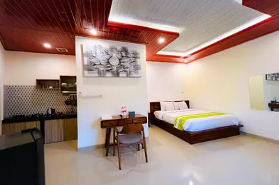 a bedroom with a bed and a table and a desk at Mora Residence Jimbaran in Jimbaran
