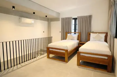 a bedroom with two beds and a railing at Manresa Villa Bali 3 in Canggu