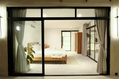 a bedroom with a bed and a large glass door at Manresa Villa Bali 3 in Canggu