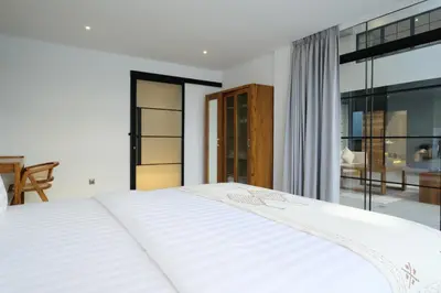 a white bed in a bedroom with a large window at Manresa Villa Bali 3 in Canggu