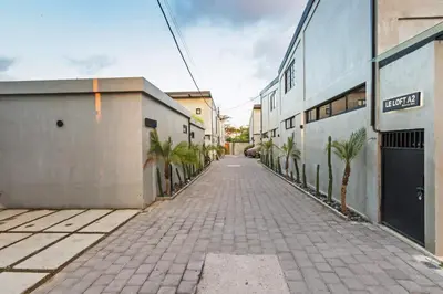 an empty alley with palm trees and buildings at Manresa Villa Bali 3 in Canggu