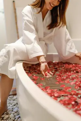 a woman in a bath tub with red confetti at Maribel Villa Bali in Seminyak