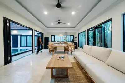 a living room with a white couch and a table at Maribel Villa Bali in Seminyak