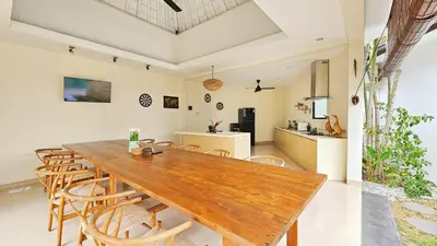 a kitchen and dining room with a wooden table and chairs at Maribel Villa Bali in Seminyak