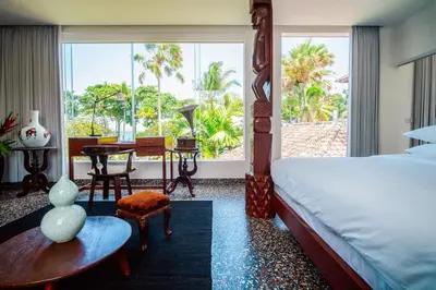 a bedroom with a bed and a desk and a window at Morabito Art Villa in Canggu