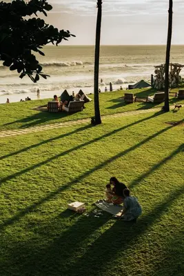 a group of people sitting on the grass at the beach at Morabito Art Villa in Canggu