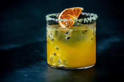 a drink with an orange slice on a table at Morabito Art Villa in Canggu