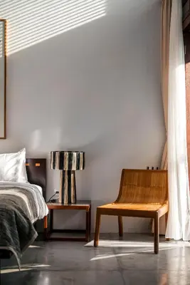 a bedroom with a bed and a wooden chair at Batu Belig Living by CPM Bali in Seminyak