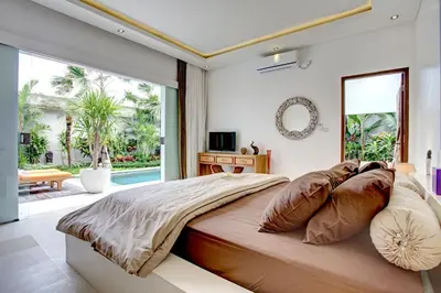a bedroom with a large bed and a large window at Villa Jonas seminyak Bali in Seminyak