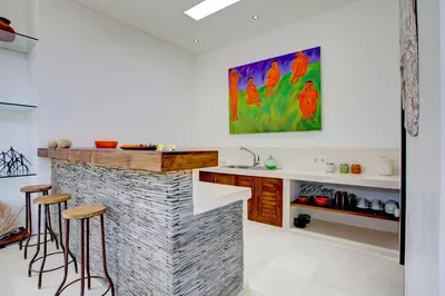 a kitchen with a counter and a bar with stools at Villa Jonas seminyak Bali in Seminyak