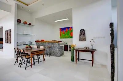a dining room with a table and a fireplace at Villa Jonas seminyak Bali in Seminyak