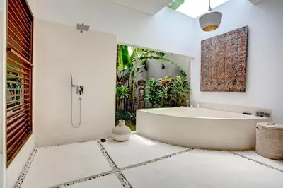 a white bathroom with a tub and a window at Villa Jonas seminyak Bali in Seminyak