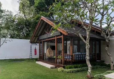 a house with a screened in porch with a tree at Villa Batu Sari in Canggu