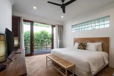 a bedroom with a bed and a large window at Villa Batu Sari in Canggu