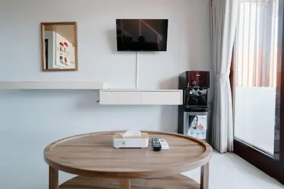 a coffee table in a living room with a tv at Pondok Puspa Sumekar in Seminyak
