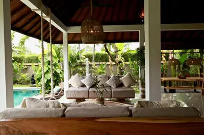 a living room with a couch and a pool at Villa Santai, huge garden Seminyak square in Seminyak