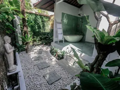 a bathroom with a bath tub and some plants at Villa Santai, huge garden Seminyak square in Seminyak
