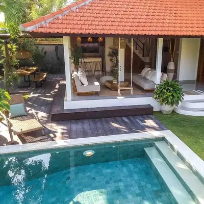 a swimming pool in front of a house at Villa Santai, huge garden Seminyak square in Seminyak